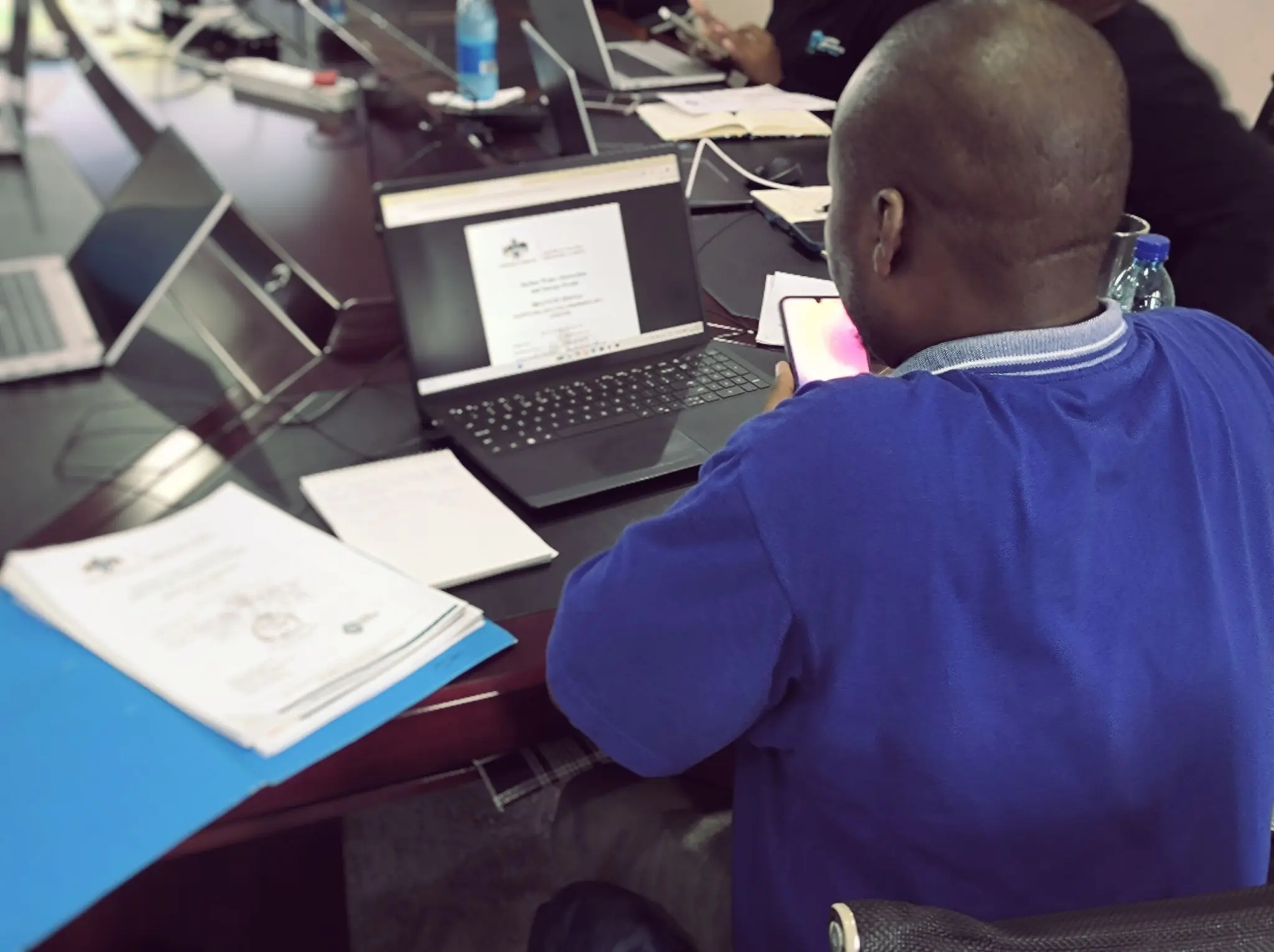 Workshop reviewing printed water licenses alongside the digital system
